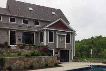 A large house with a swimming pool in front of it