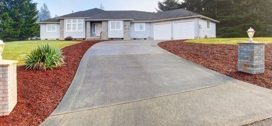 A large white house with a long driveway leading to it.