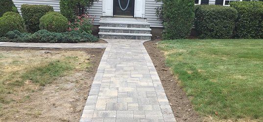 A brick walkway leading to the front door of a house.