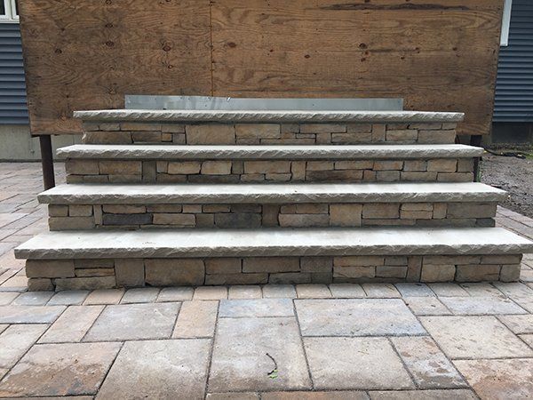 A set of stone stairs sitting on top of a brick patio.