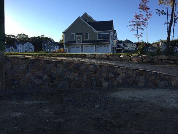 A large house with a stone wall in front of it
