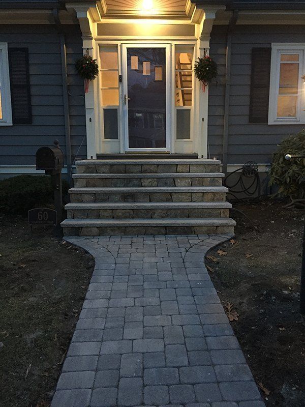 A brick walkway leading to the front door of a house
