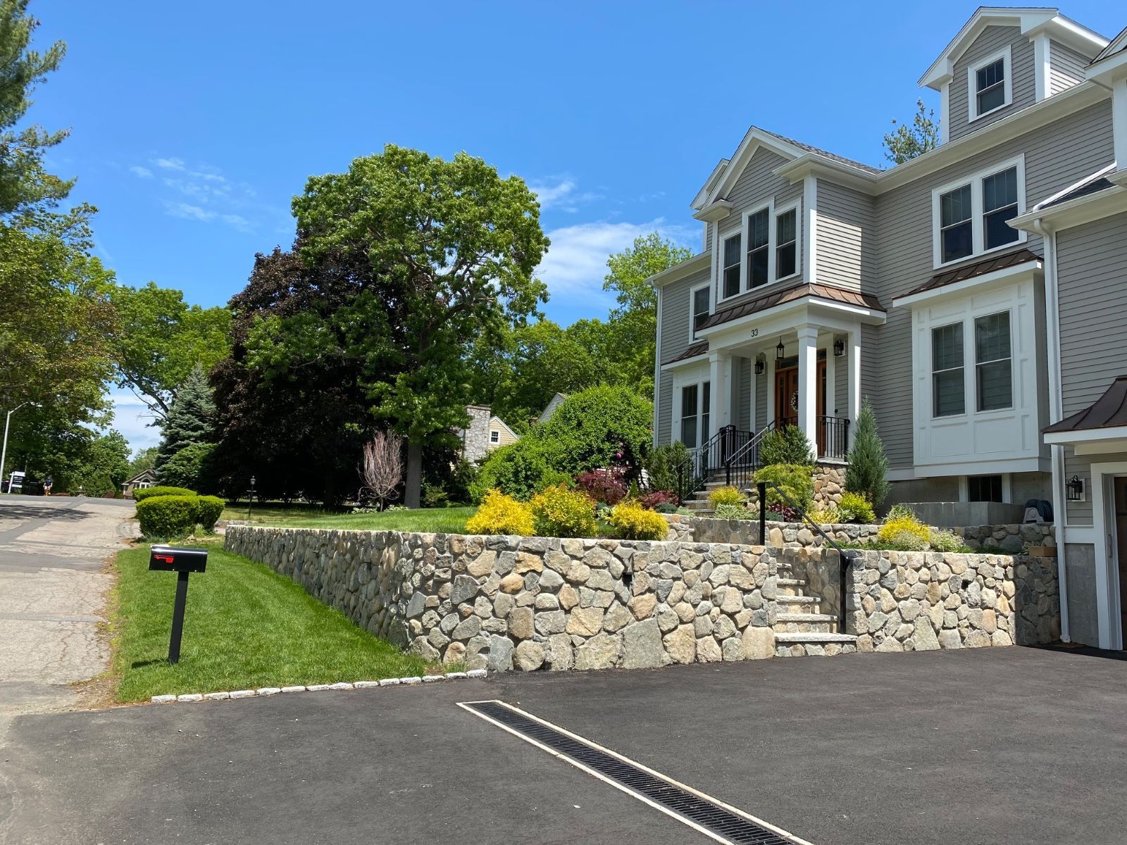 A large house with a stone wall in front of it