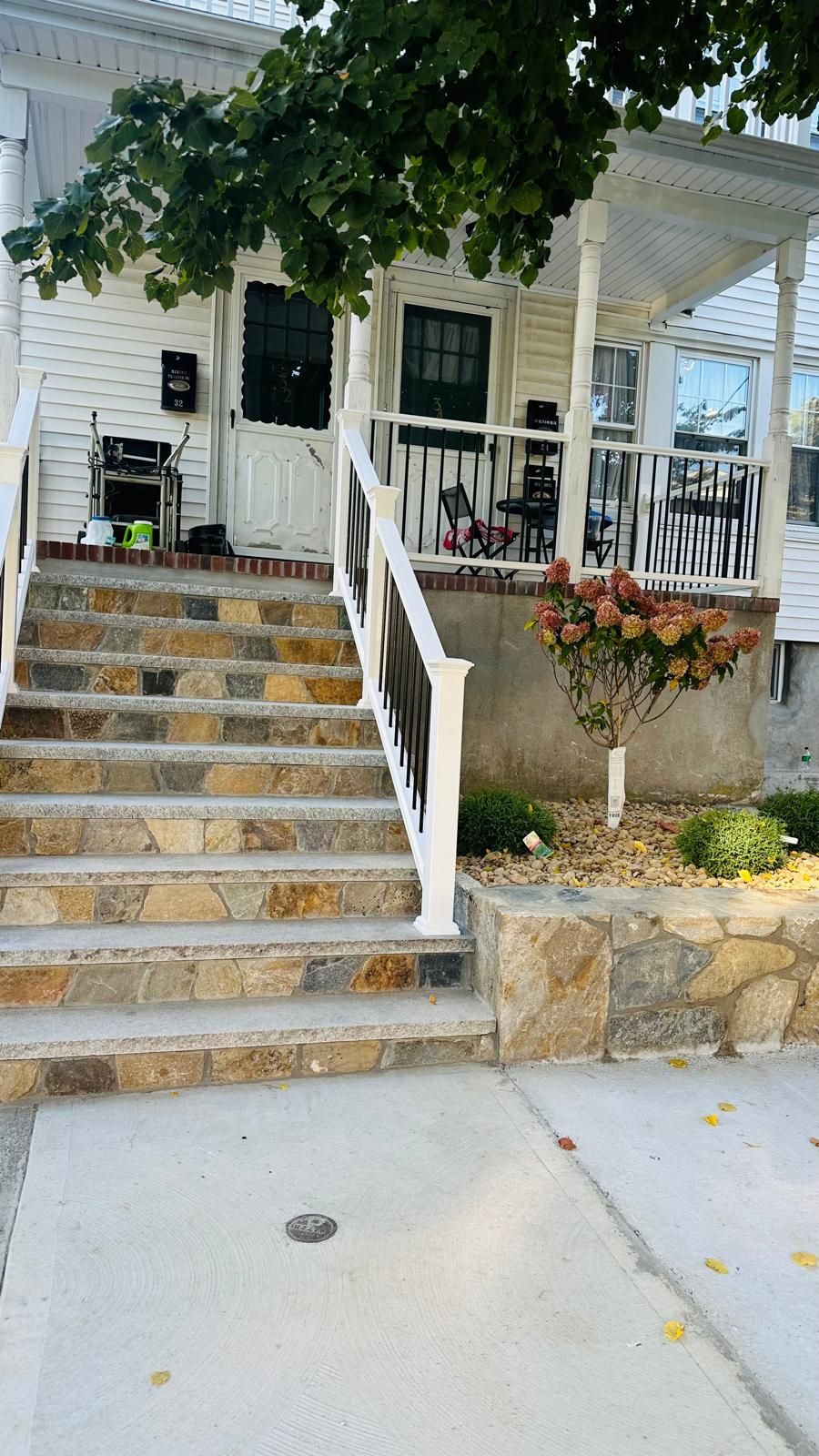 A house with a porch and stairs leading up to it.