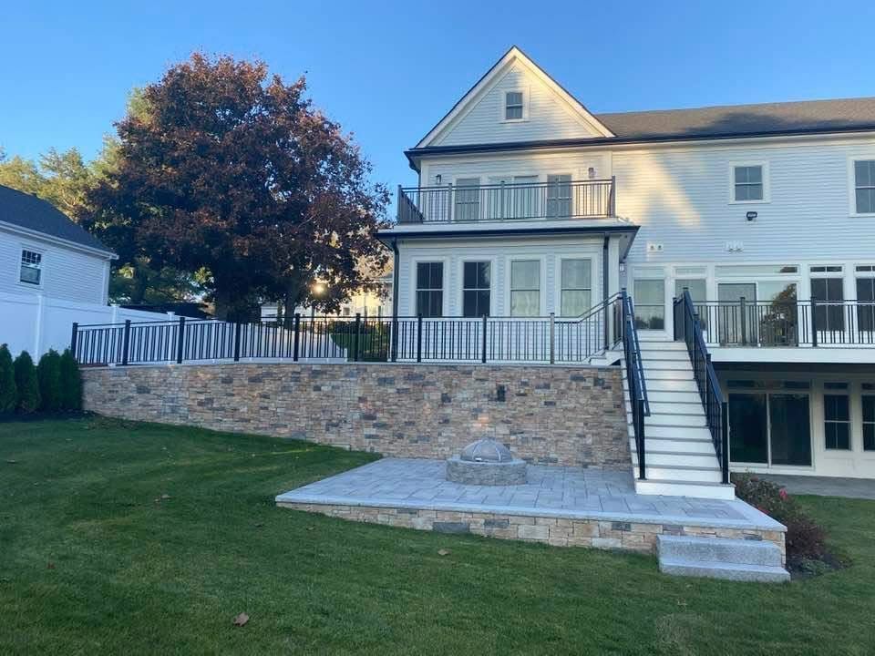 A large white house with a patio and stairs in front of it.
