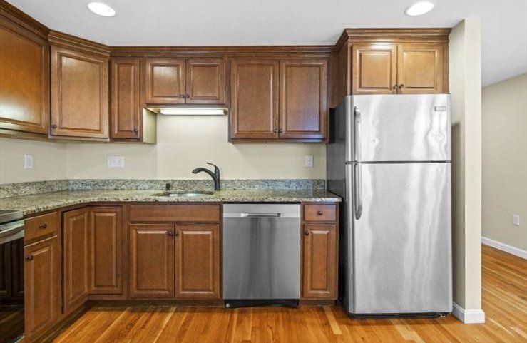 A kitchen with stainless steel appliances and wooden cabinets