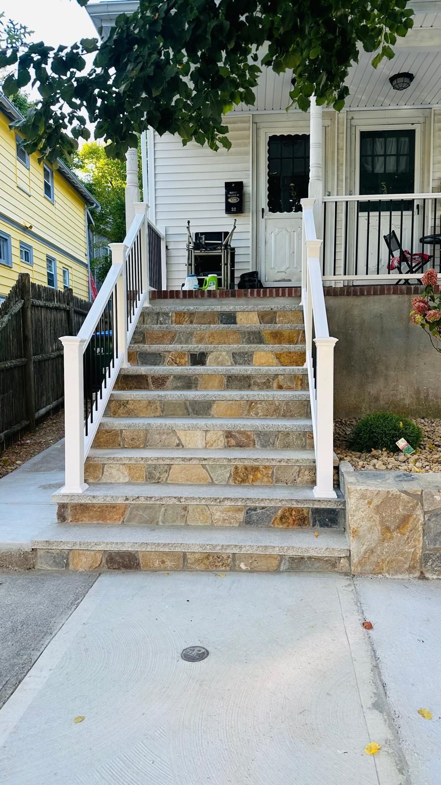 A set of stairs leading up to a house with a white railing.