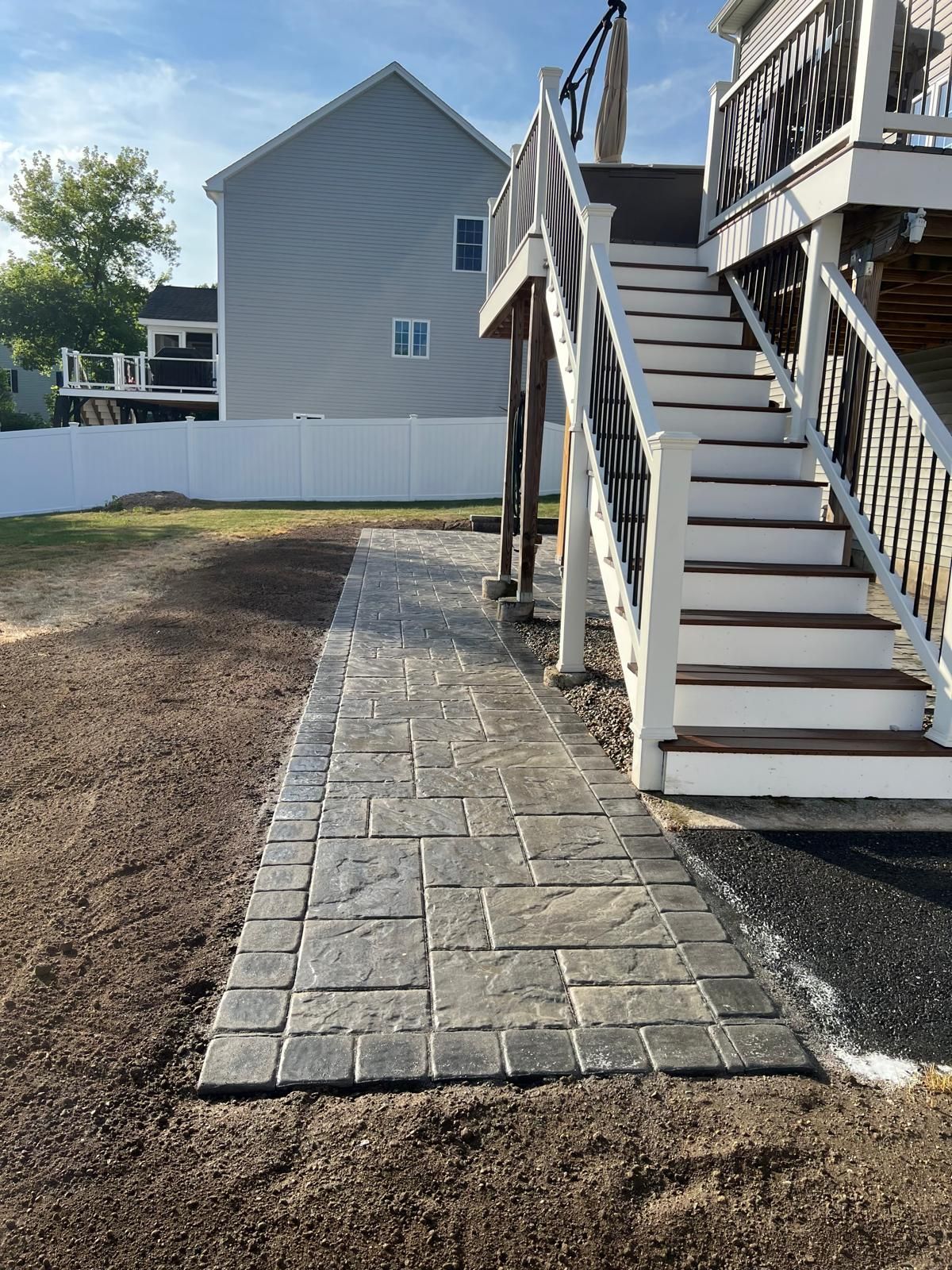 A walkway leading to a deck with stairs leading up to it.