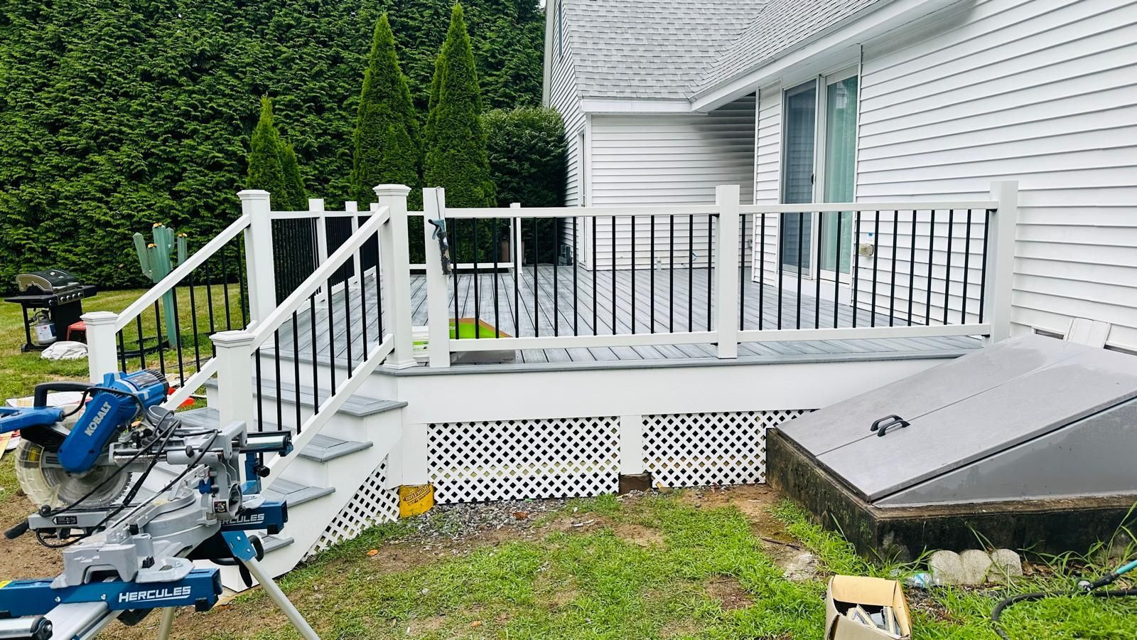 A white house with a deck and stairs being built.