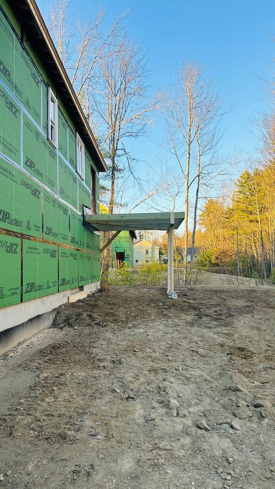 A house is being built in the middle of a dirt field.