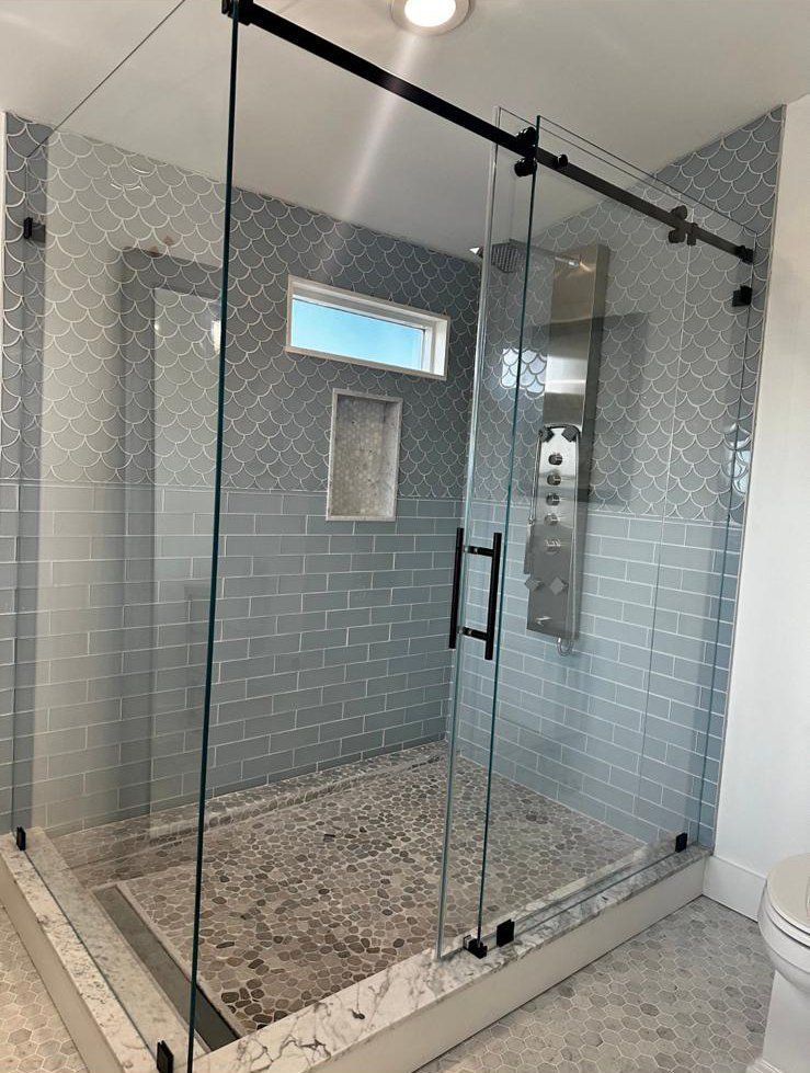 A bathroom with a sliding glass shower door and a toilet.