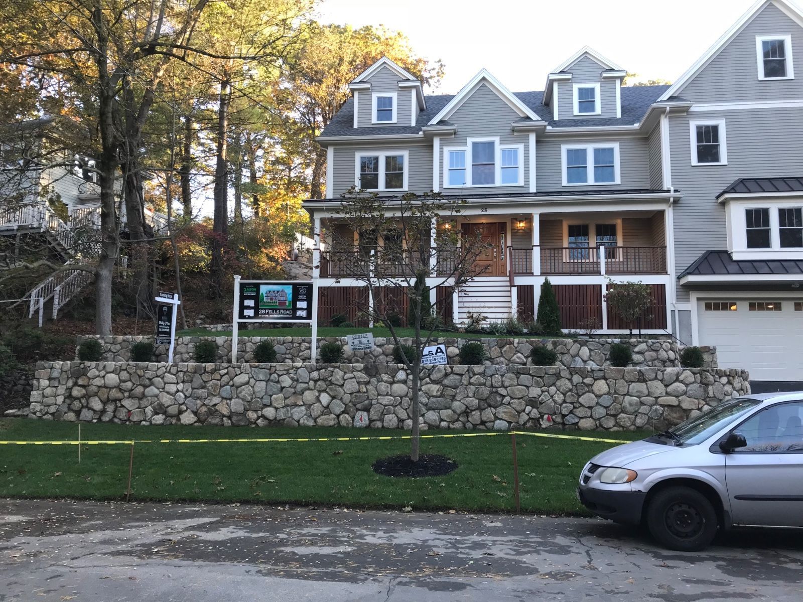 A white van is parked in front of a large house