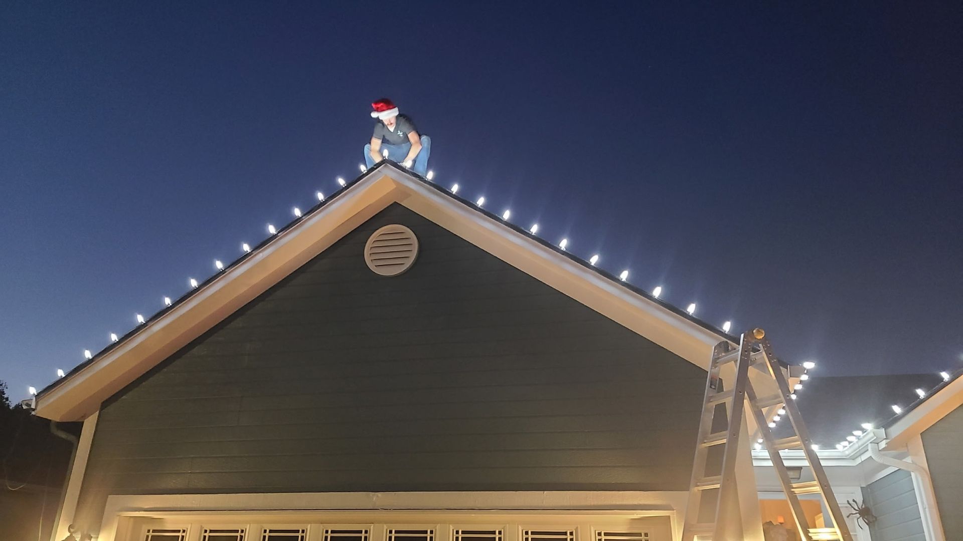 Person on roof installing Christmas lights