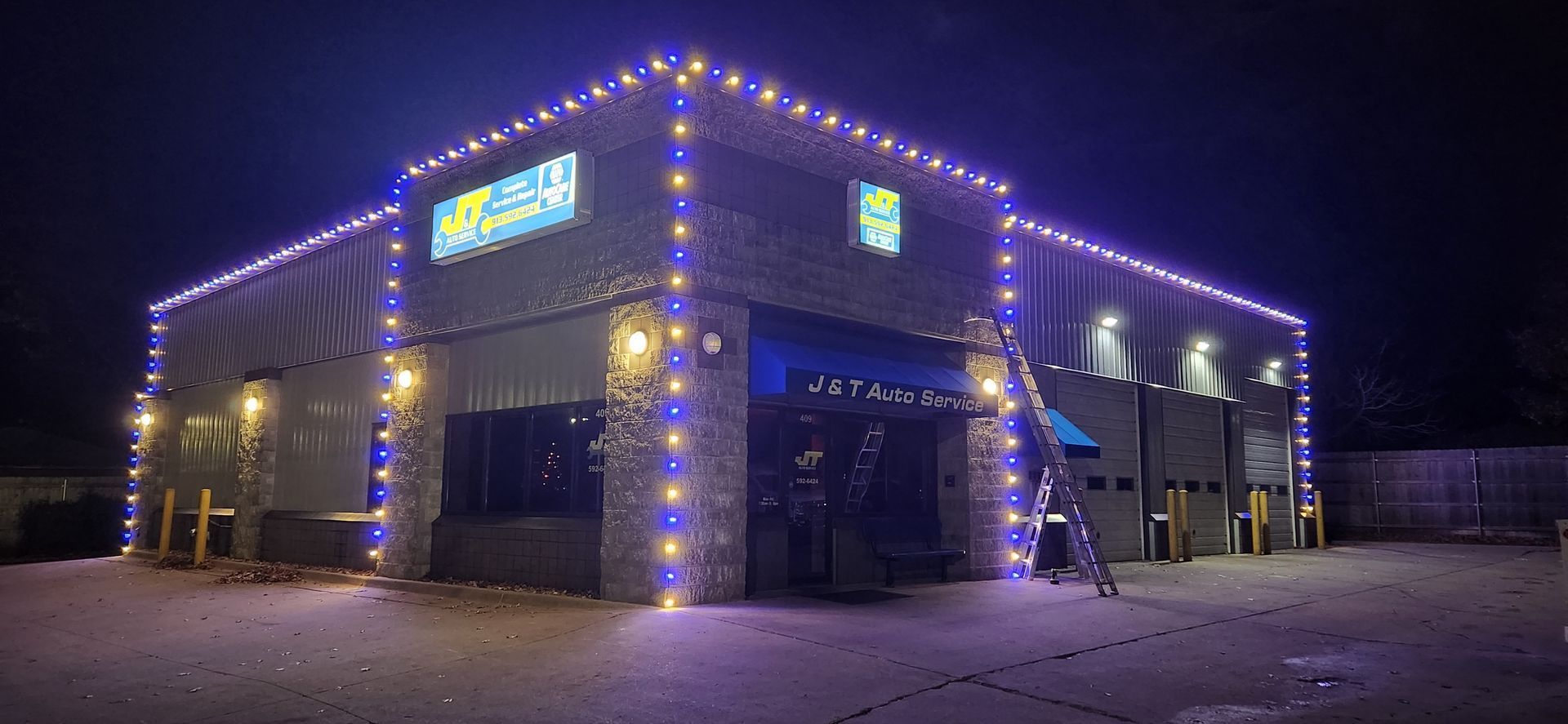 Building exterior at night with blue and white holiday lights.