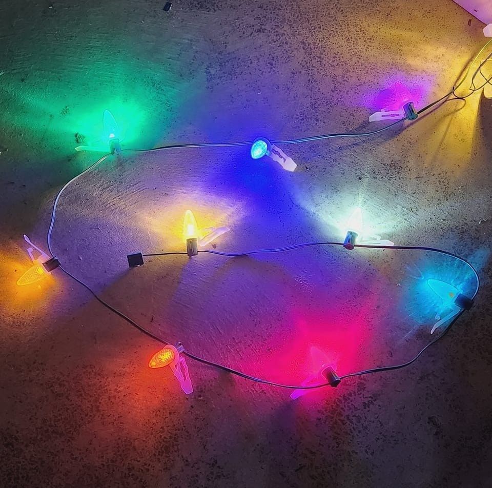 String of colorful fairy lights on a dark surface.