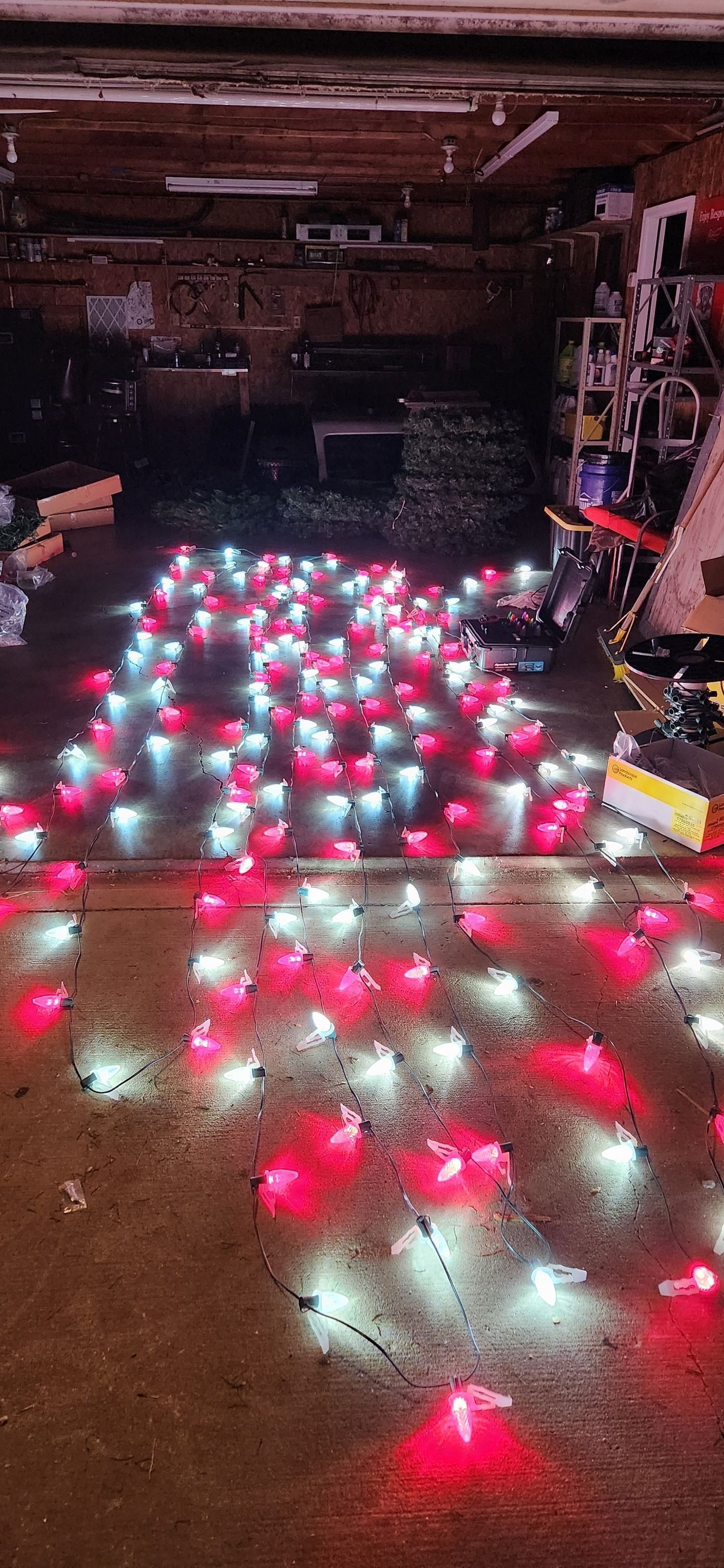 Red and white lights scattered on a concrete floor, in a dimly lit garage or workshop.