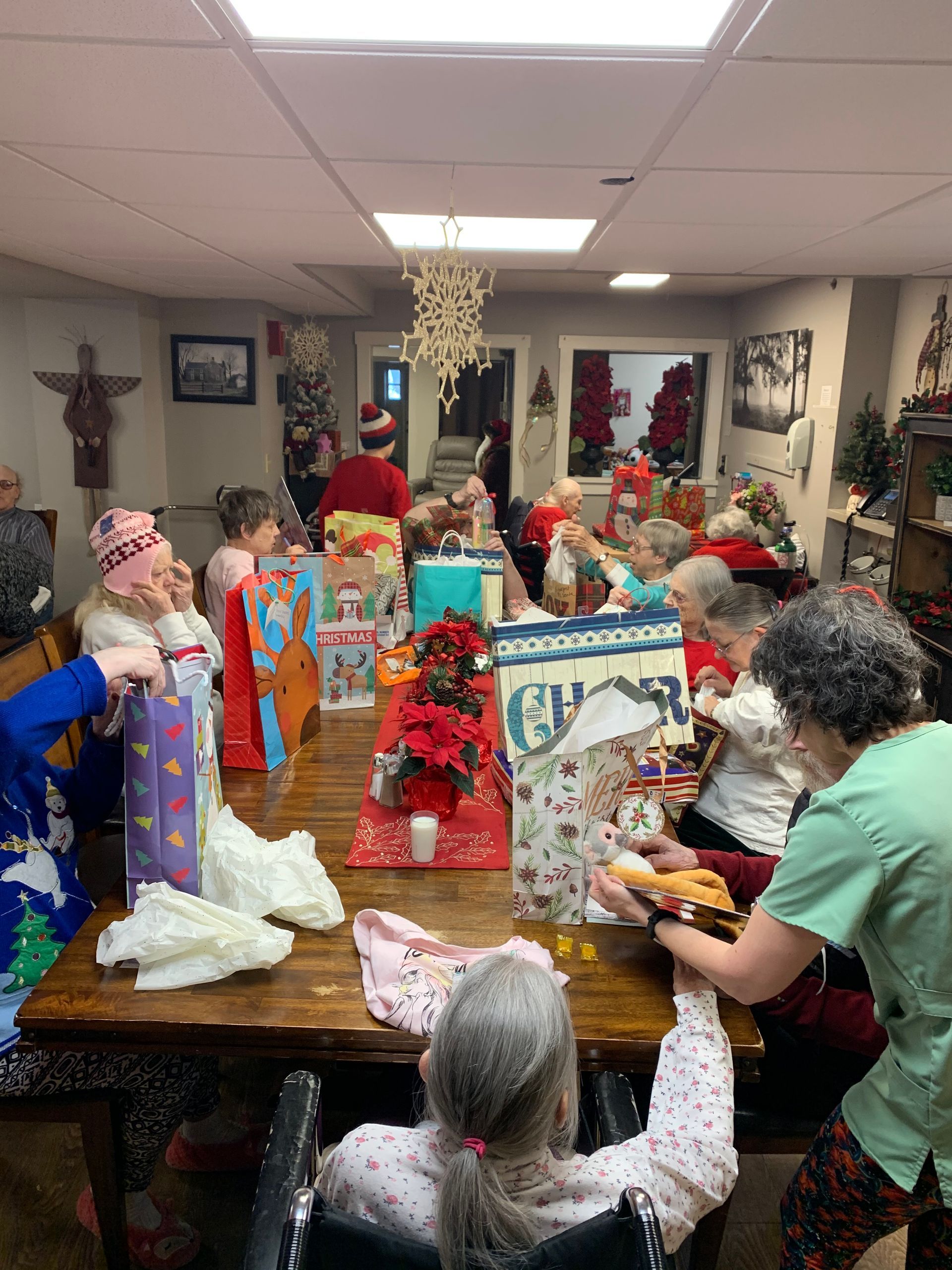 A group of people are sitting around a table with gifts.