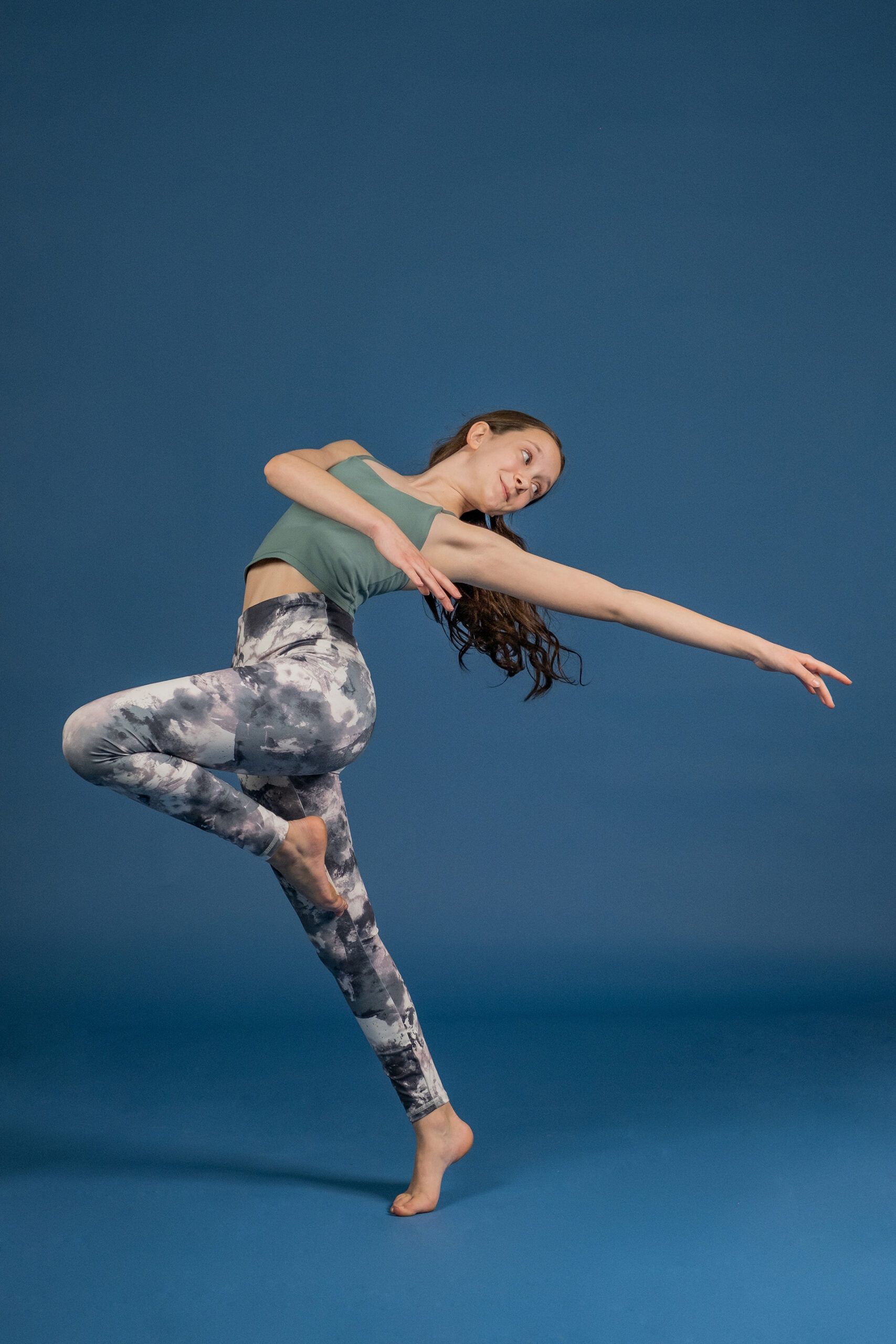 A woman is dancing on a blue background.