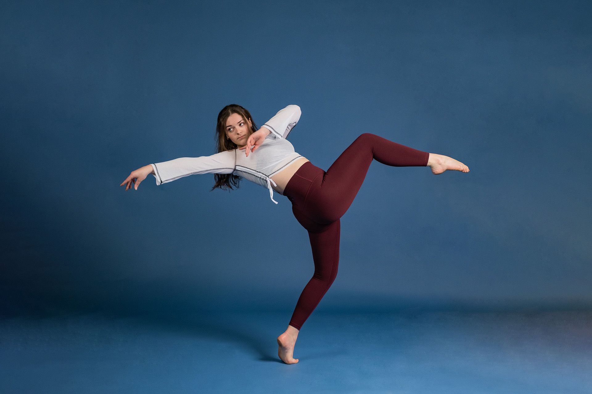 A woman is dancing on a blue background.