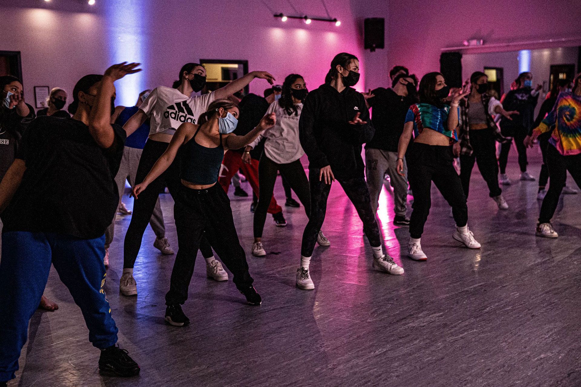 A group of people are dancing in a dance studio.