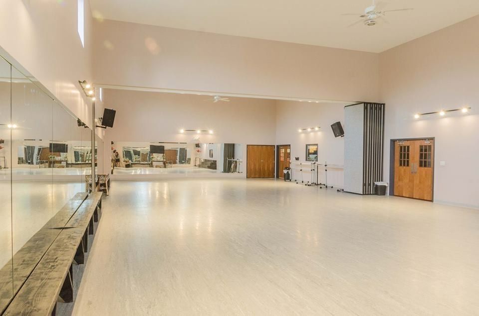 a large empty dance studio with a large mirror on the wall