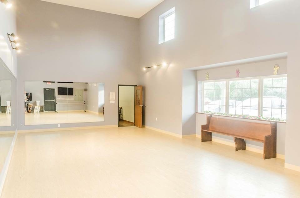a large empty dance studio with a lot of windows and mirrors