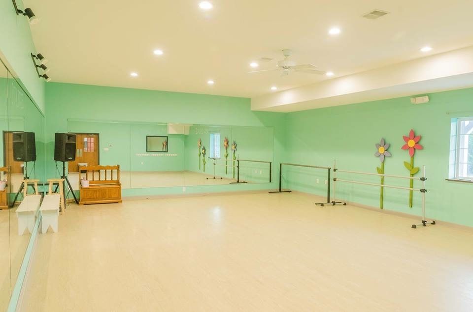 an empty dance studio with a large mirror and ballet barres