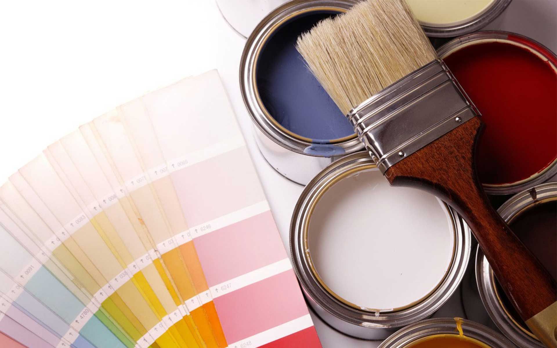 A brush is sitting on top of a bunch of paint cans