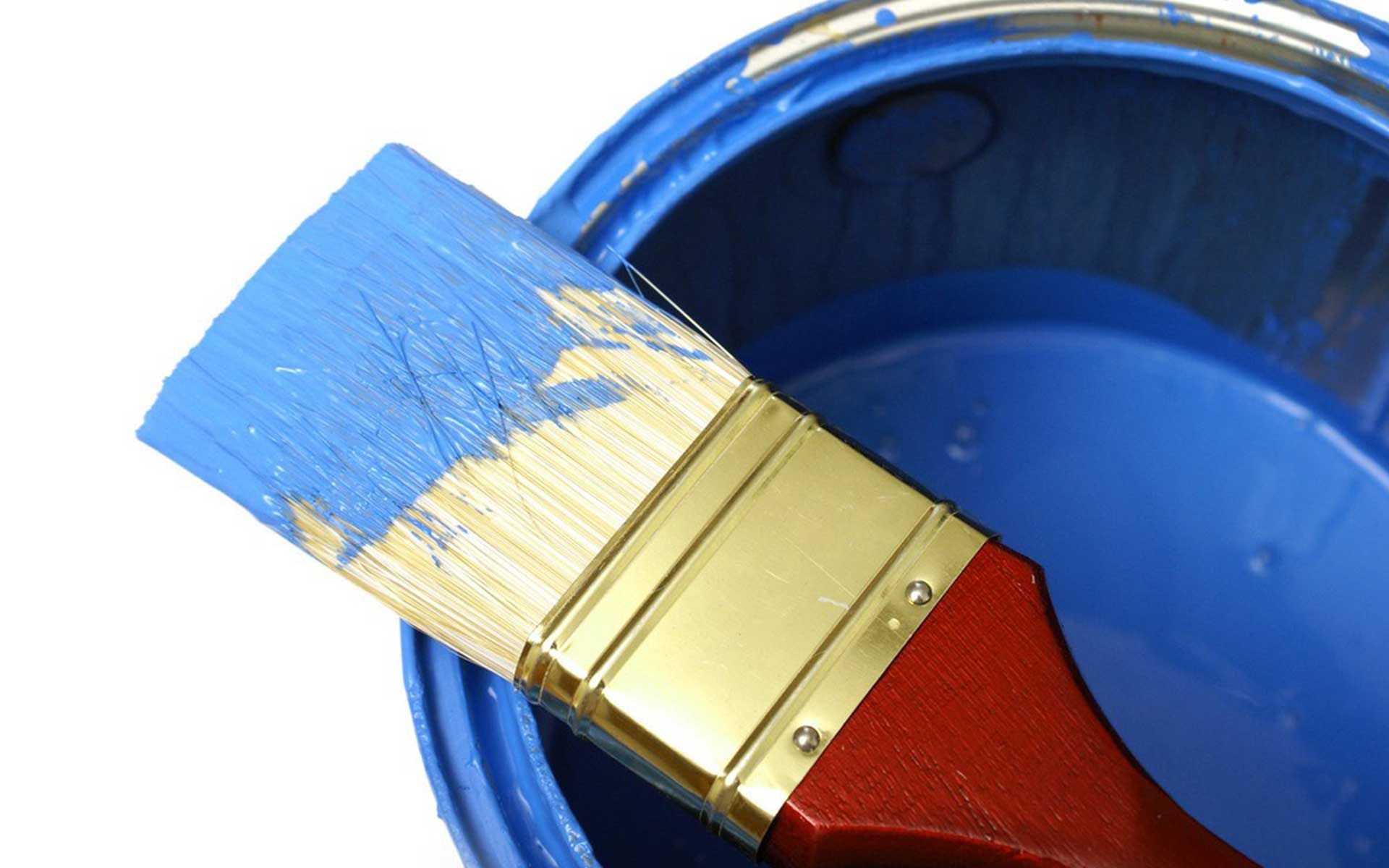 A blue paint can with a brush in it