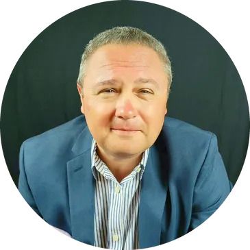 A man in a blue suit and striped shirt is sitting in a circle.