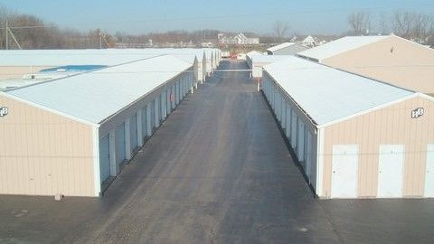 A row of buildings with white roofs are lined up next to each other.