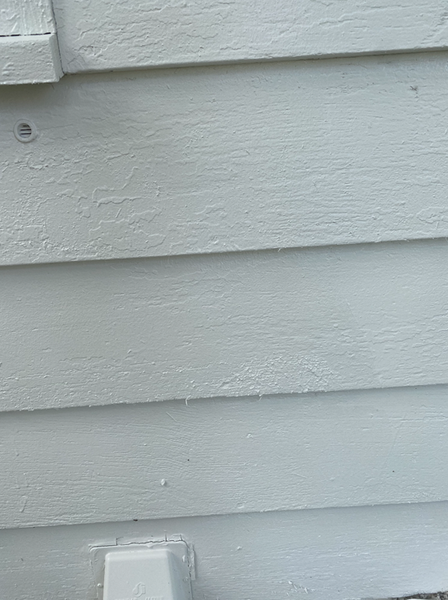 White painted siding on a building, with horizontal clapboard boards.