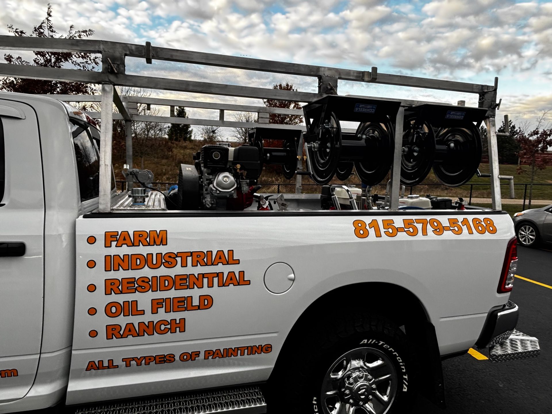 White work truck with equipment rack and services listed on side. Phone number: 815-579-5188.