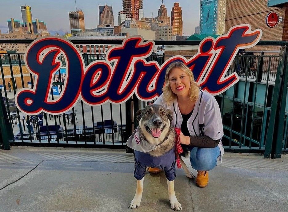 Woman and dog pose by a 