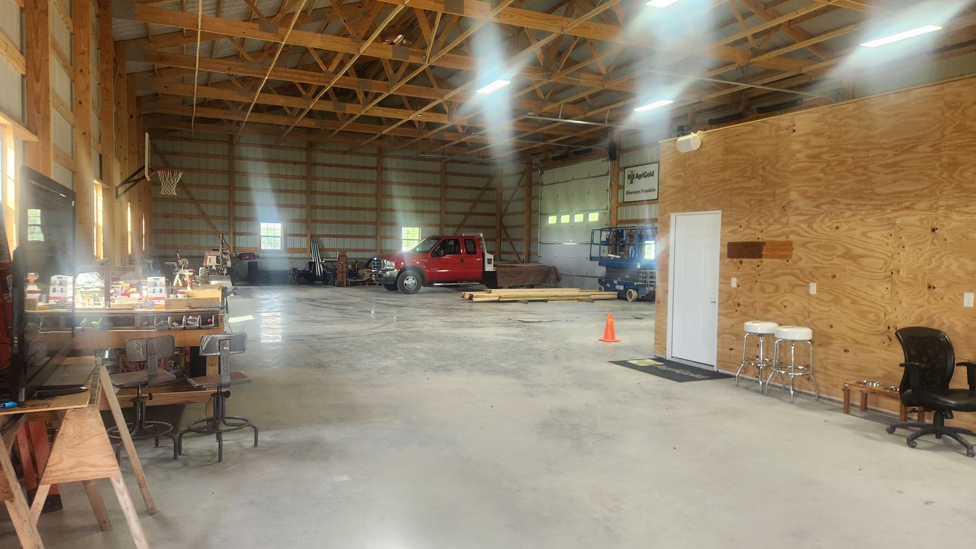 A large warehouse with a red truck parked inside of it.