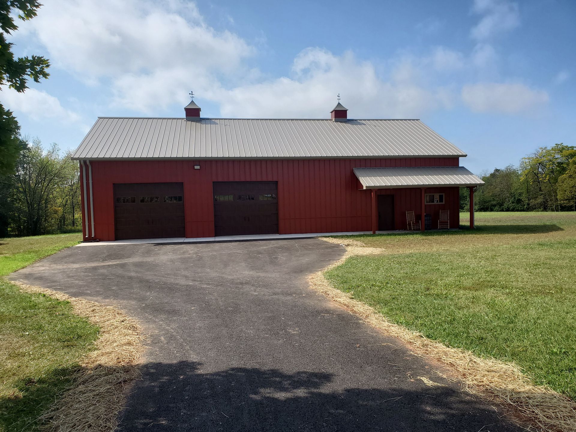 A red barn sits in the middle of a grassy field