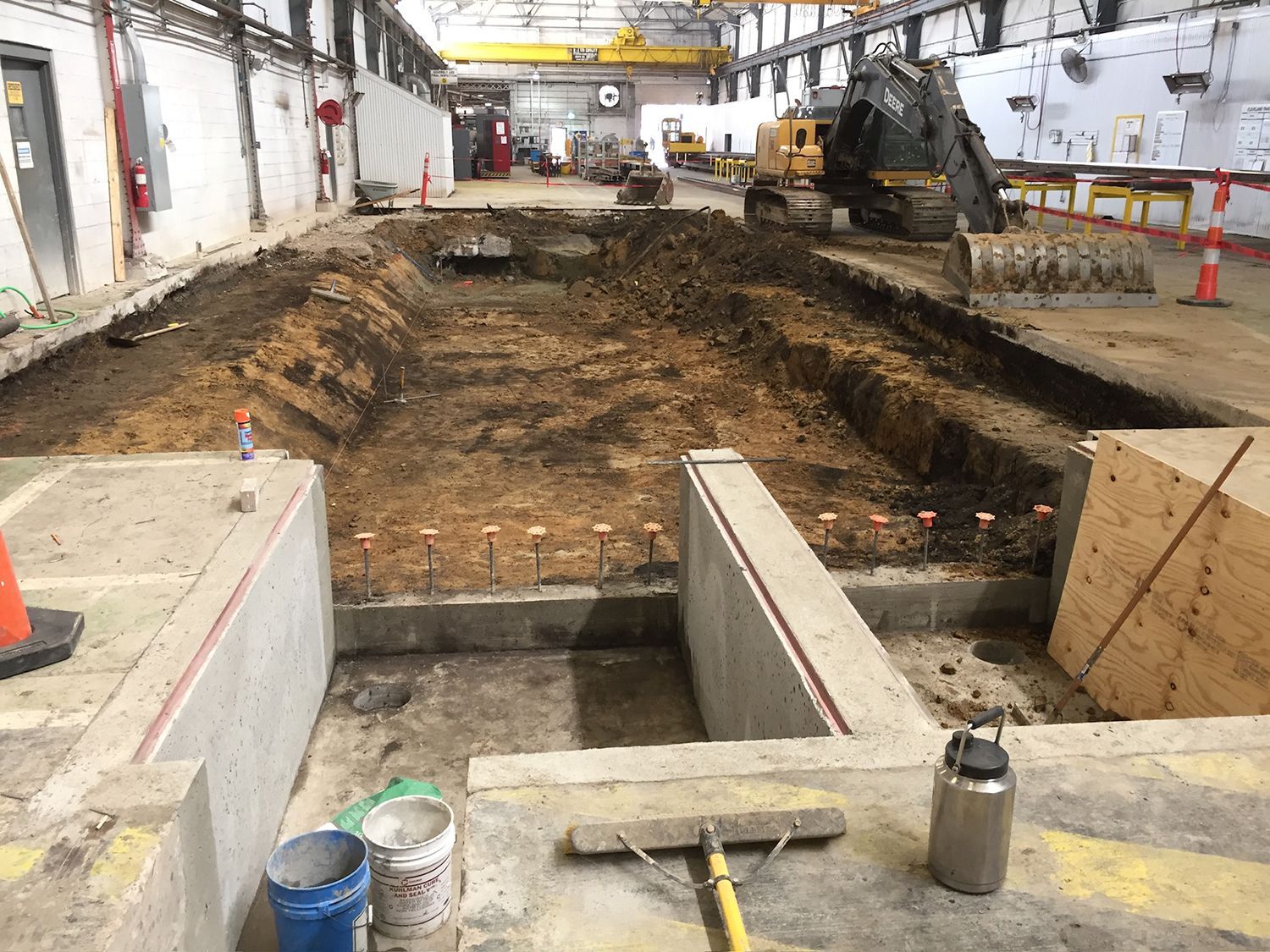 There is a large hole in the ground in the middle of a building.