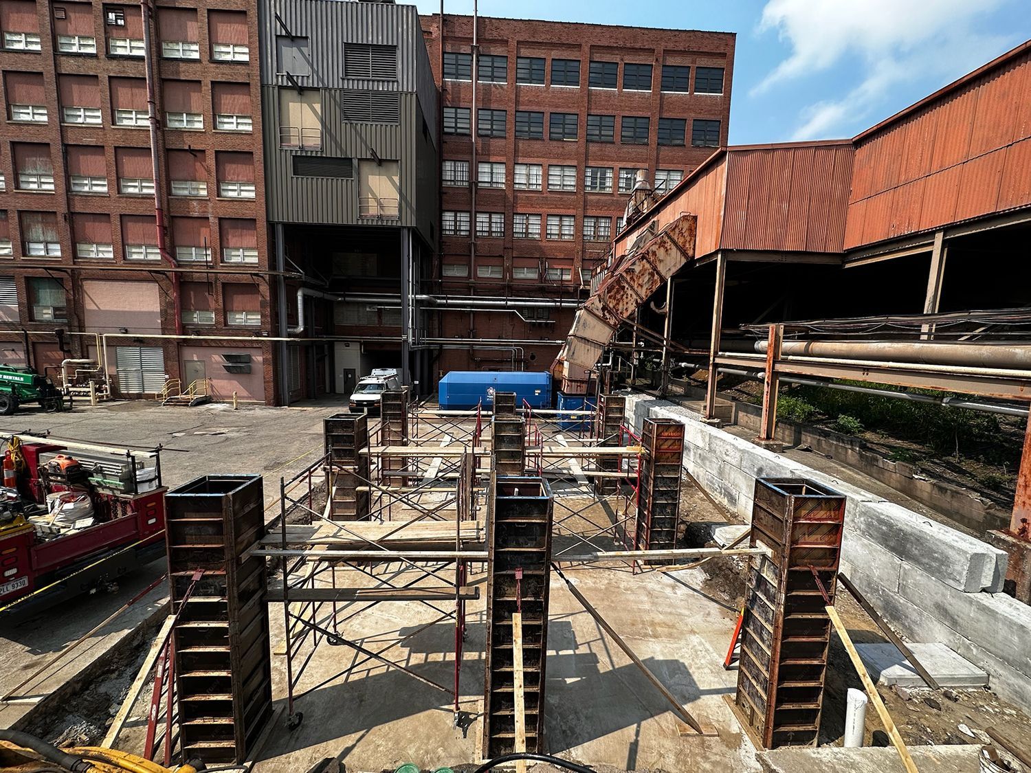 A construction site with a large building in the background.