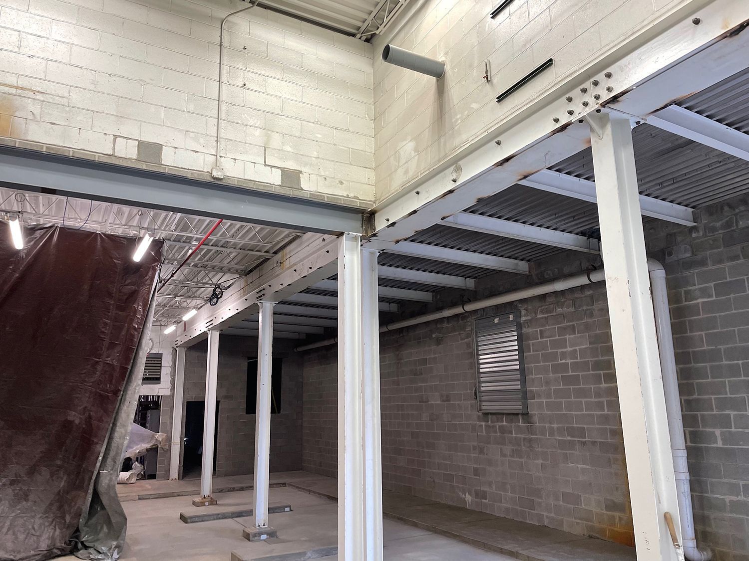 The inside of a building with brick walls and white pillars.