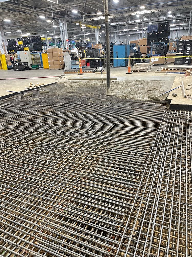 A large warehouse with a lot of steel bars on the floor.