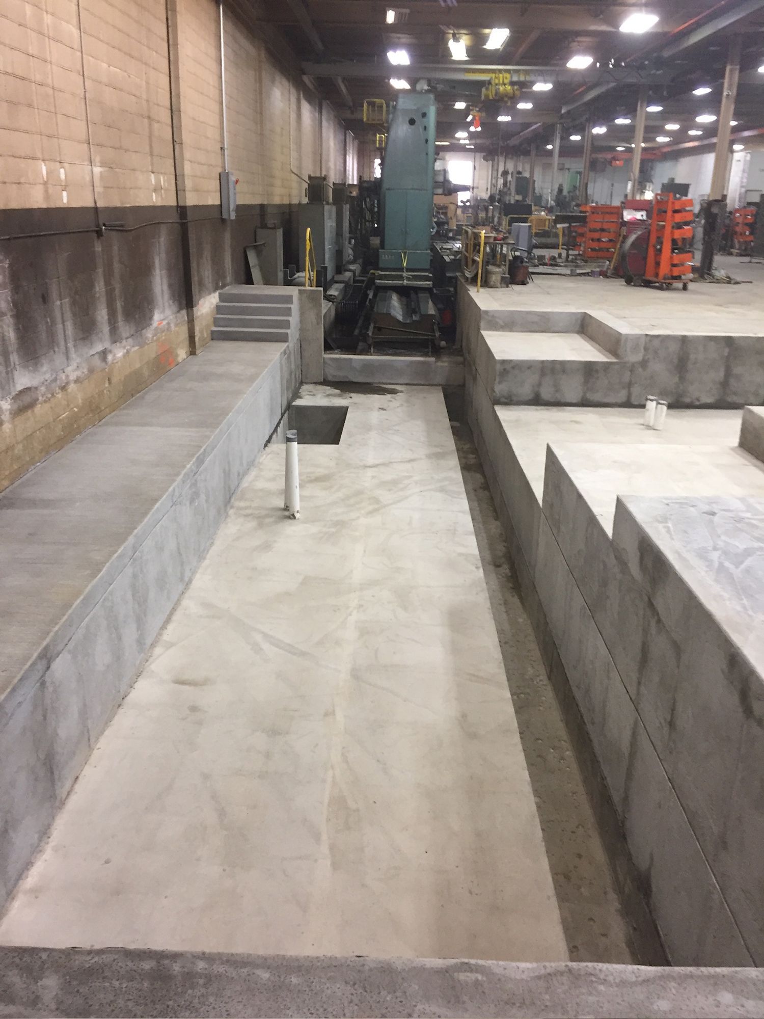 A large machine is sitting in the middle of a warehouse.