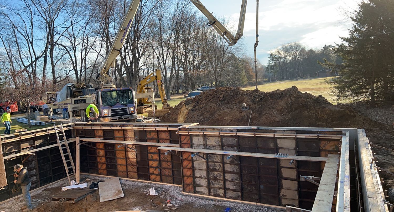 A concrete pump is being used to pour concrete into a building under construction.