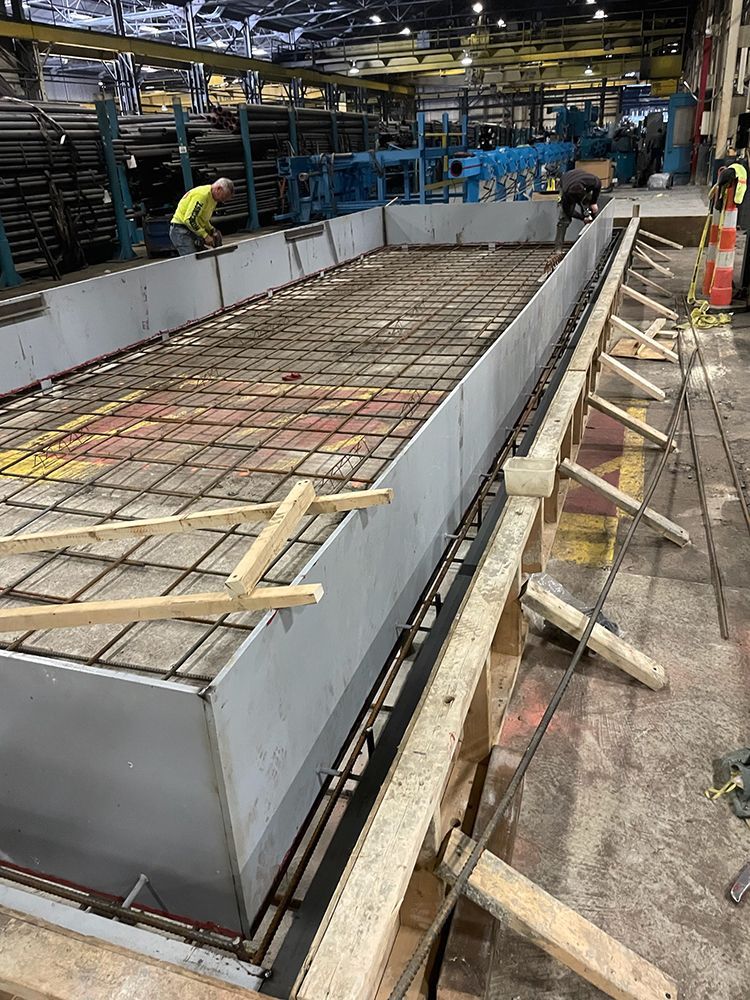 A man is working on a concrete slab in a factory.