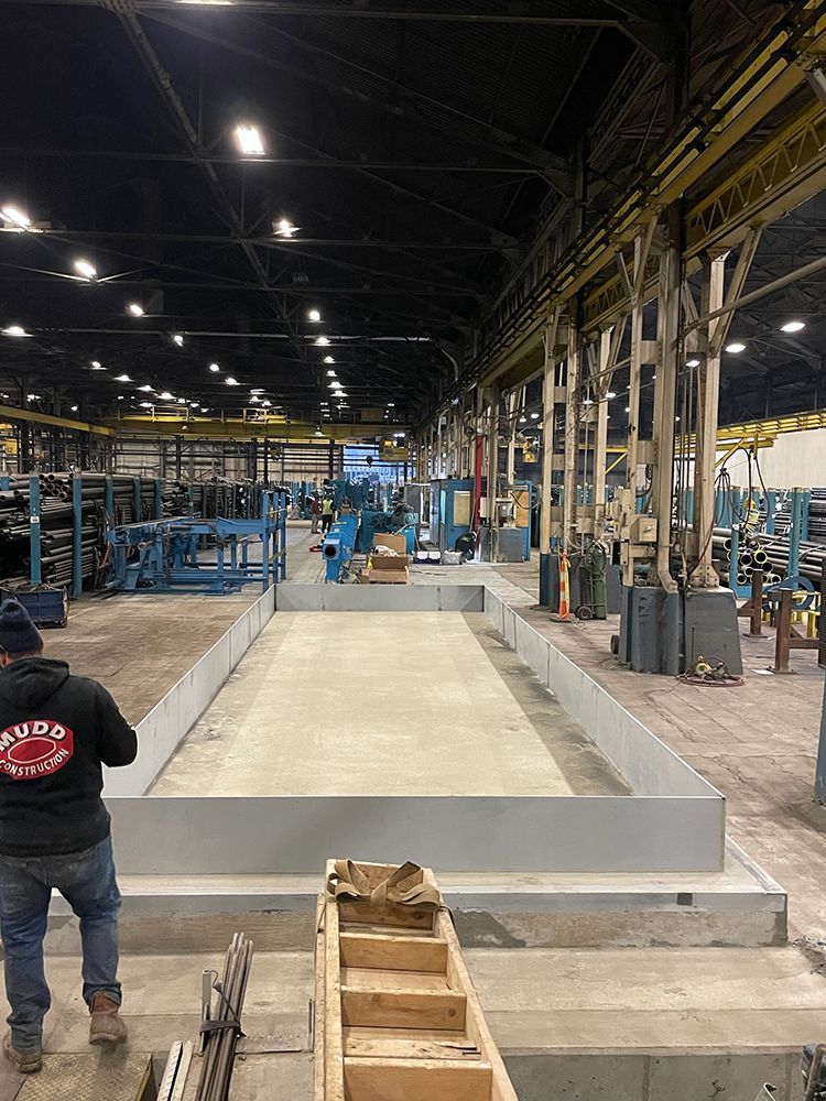 A man is standing in the middle of a large warehouse.
