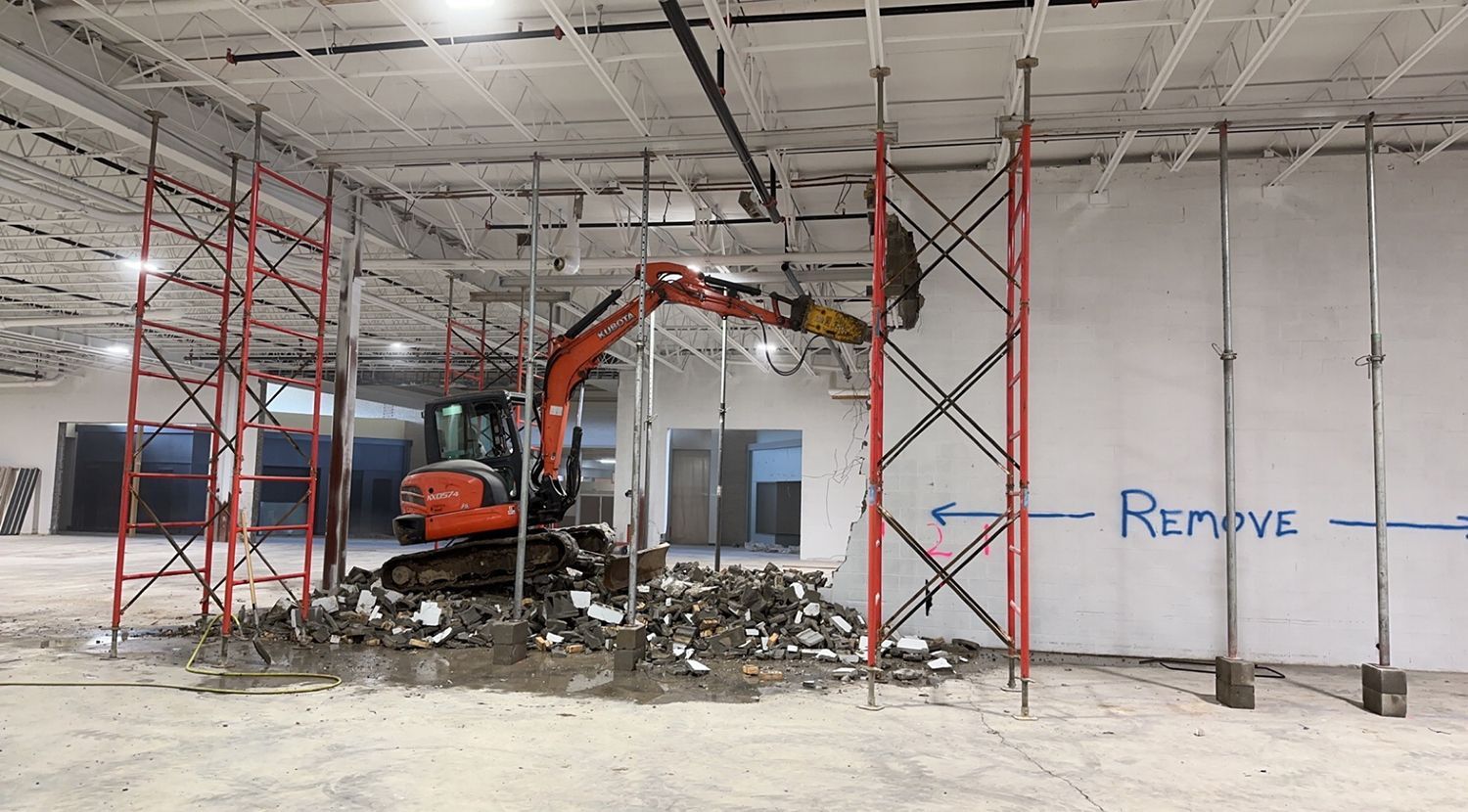 A large building is being demolished with a bulldozer.