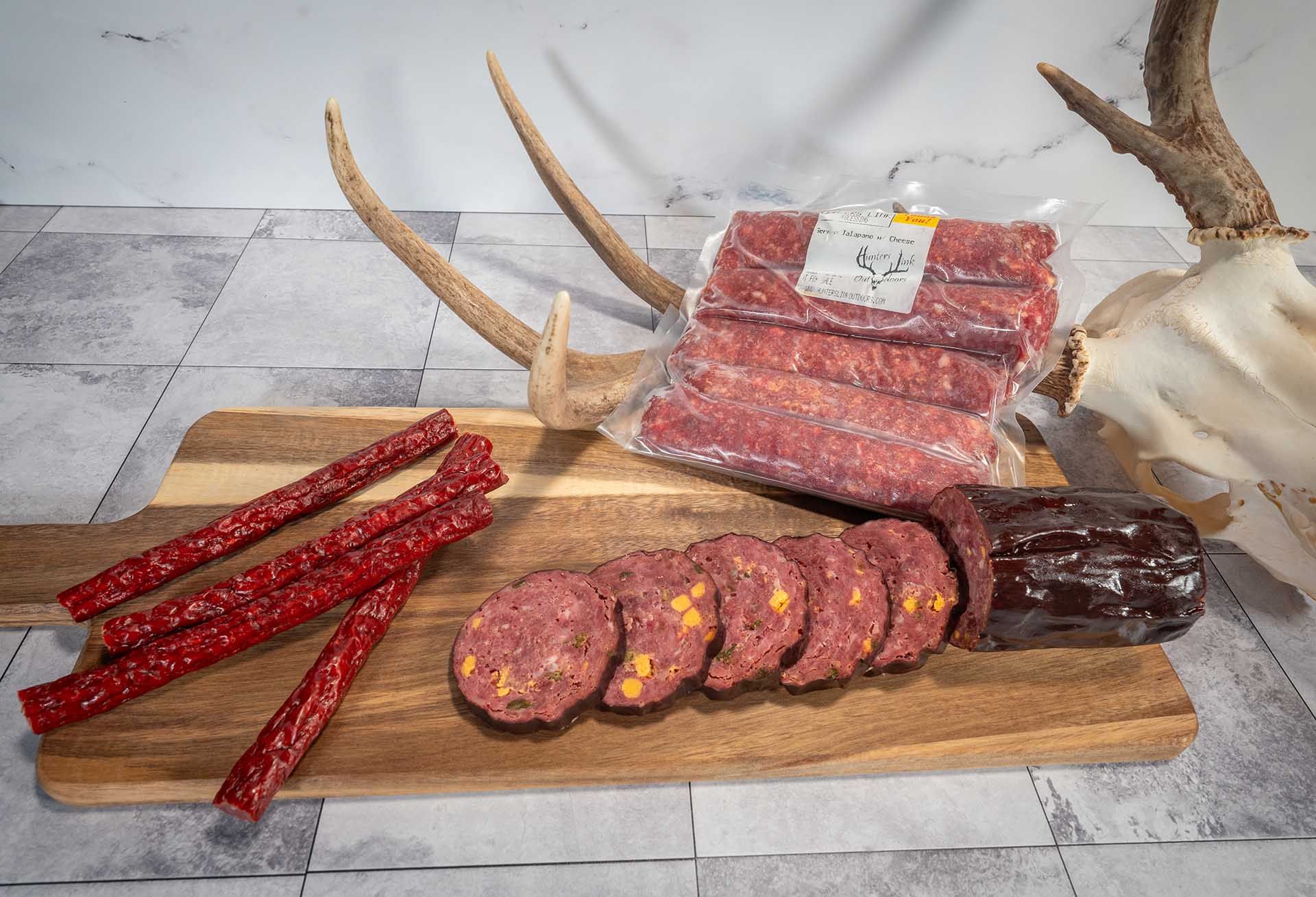 A wooden cutting board topped with varieties of sausage.