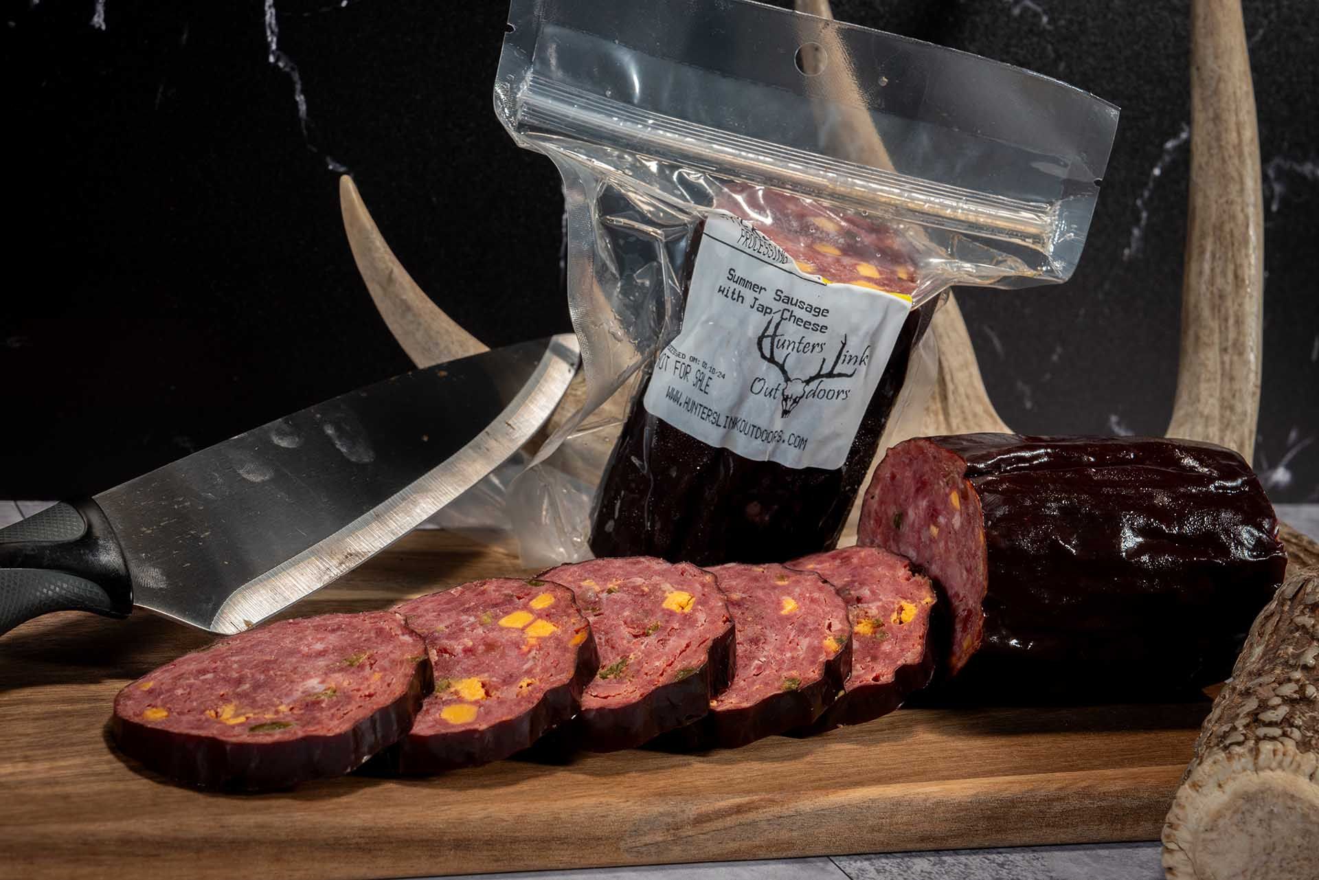 Closeup of a cutting board and knife with summer sausage