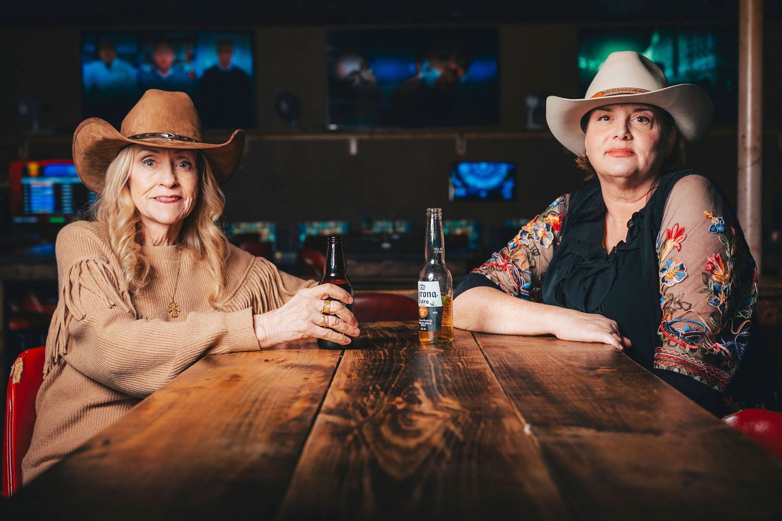 two women at the bar wearing cowboy hats