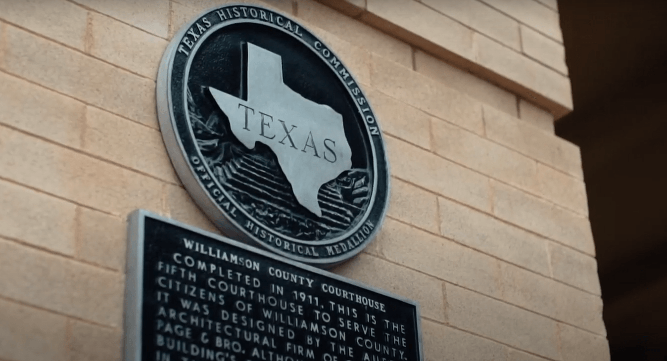A plaque on the side of a building that says texas