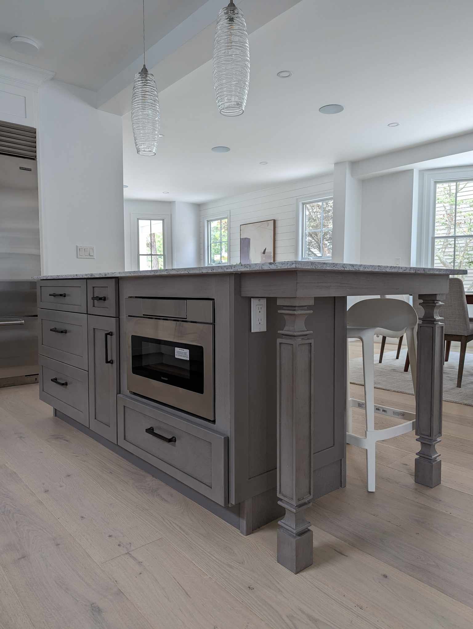 A kitchen with a large island and a microwave oven.